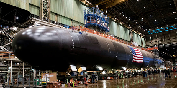 The USS Iowa SSN 797 in the construction process, contrasting largely in scale with the workers building it